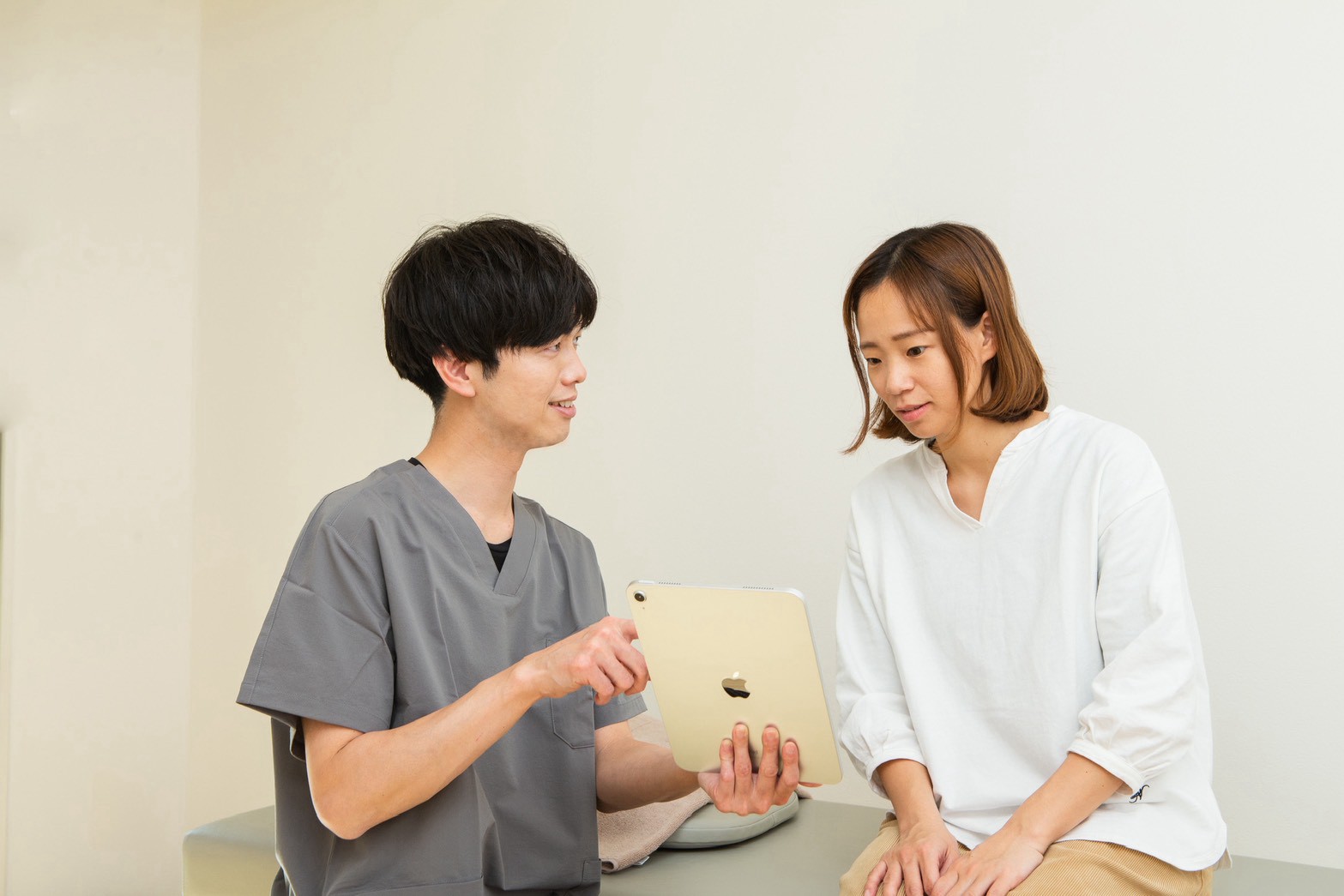 院長が、タブレットを見せながら説明している様子