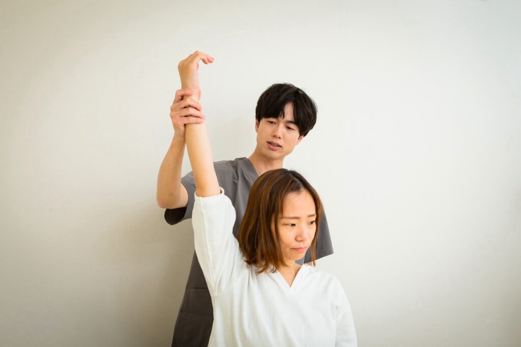 立った姿勢で、腕の上がり方や動きを確認している様子